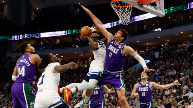 Anthony Edwards shoots a layup defended tightly by Brook Lopez